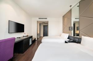 a hotel room with two beds and a flat screen tv at Orange Hotel Shanghai Hongqiao Airport Caoan Road Branch - Free Hongqiao Airport & Hongqiao Train station Shuttle Bus in Shanghai