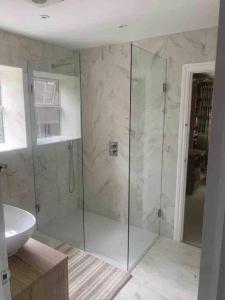 a bathroom with a glass shower and a sink at Stunning Racecourse Townhouse for Royal Ascot in Winkfield