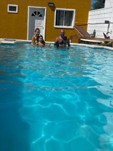 mężczyzna, kobieta i dziecko w basenie w obiekcie CÁBAÑAs , S,E,2 w mieście Villa Los Aromos