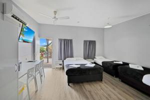 a hotel room with two beds and a desk at Ned Kelly's Motel in Maryborough