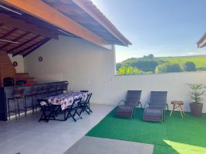 a patio with a table and chairs and a green rug at Chacara em Socorro- SP próx ao centro, com piscina e area gourmet in Socorro
