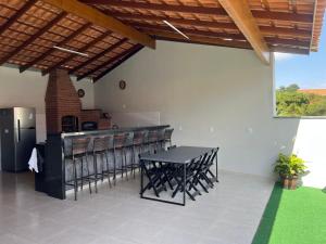 a patio with a table and chairs and a bar at Chacara Pinheiros piscina climatizada Próx a feira de malhas, Socorro SP in Socorro