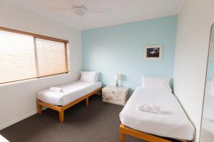 sypialnia z 2 łóżkami i oknem w obiekcie Six River - LJHooker Yamba w mieście Yamba