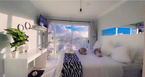 Habitación con cama y ventana en Kwaaamiii, en Ciudad del Cabo