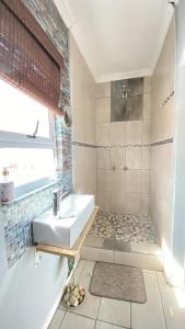 y baño pequeño con lavabo y ducha. en Kwaaamiii, en Ciudad del Cabo