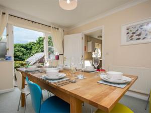 a dining room with a wooden table with chairs at 3 Bed in Studland DC072 in Studland