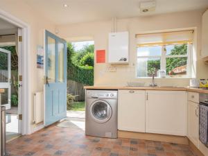 a kitchen with a washing machine and a sink at 3 Bed in Studland DC072 in Studland