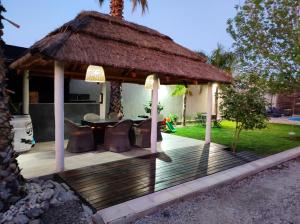 a wooden gazebo with a thatched roof at Loft & Wines in Maipú