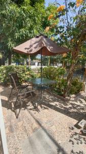 einen Picknicktisch, einen Regenschirm und einen Stuhl in der Unterkunft Alojamiento Monik in Ríohacha