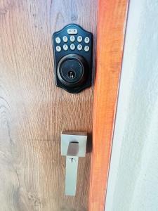un mando a distancia en una puerta de madera con un interruptor en Perro Loco Villas en Paraíso