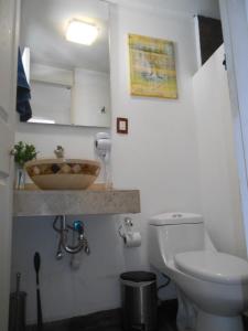 y baño con aseo blanco y lavamanos. en San Ángel Colonial, en Ciudad de México