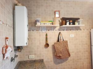 a tiled bathroom with a purse on the wall at La Posadita Familiar in Yerba Buena