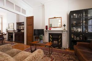 a living room with a couch and a fireplace at Charming 3-Bedroom Terrace in the Heart of Glebe in Sydney