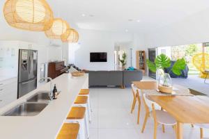 uma cozinha e sala de estar com mesa e cadeiras em The Beach Oasis ~ 360 em Kingscliff