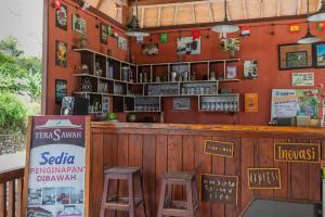 un restaurante con dos taburetes en un bar en Teras Sawah Guest House Syariah, en Sembalun Lawang