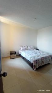 een slaapkamer met een bed en een nachtkastje bij Santa Rosa De Cabal - Acogedor apartamento in Santa Rosa de Cabal