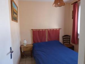 ラ・トランシュ・シュル・メールにあるMaison La Tranche-sur-Mer, 3 pièces, 5 personnes - FR-1-194-12のベッドルーム1室(青いベッド1台、デスク、赤いカーテン付)