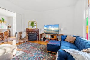 ein Wohnzimmer mit einem blauen Sofa und einem TV in der Unterkunft Maple Manor in Saint Paul