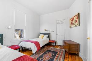 1 dormitorio con 2 camas, mesa y alfombra en Maple Manor, en Saint Paul