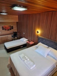 une chambre d'hôtel avec deux lits et une chaise dans l'établissement Casa de campo na cidade, à Foz do Iguaçu