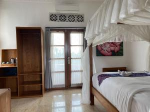 um quarto com uma cama de dossel em Narasoma Homestay & Retreat em Ubud