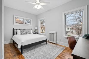 een witte slaapkamer met een bed en 2 ramen bij Sapphire Estate in Minneapolis