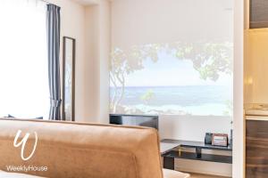 a living room with a couch and a view of the beach at WeeklyHouse Silto Crete - Vacation STAY 61955v in Otsu