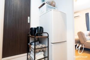 a kitchen with a refrigerator and a shelf with towels at WeeklyHouse Silto Crete - Vacation STAY 61955v in Otsu