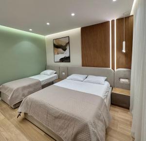 ein Hotelzimmer mit zwei Betten und einem Fenster in der Unterkunft Luxurious Dreamy seaside apartment in Durrës