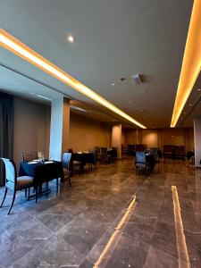 MIRADOR HOTEL في المنامة: غرفة طعام مع طاولات وكراسي في مبنى
