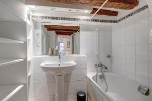 a white bathroom with a sink and a bath tub at 676 Suite Noam - Elegant Apartment in Paris in Paris
