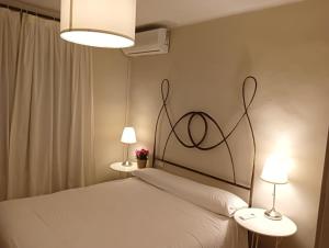 サアラ・デ・ロス・アトゥネスにあるExclusivo Zahara Urb Bahia de la Plataのベッドルーム1室(白いベッド1台、ランプ2つ付)
