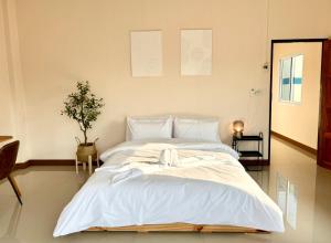 sypialnia z dużym łóżkiem z białą pościelą w obiekcie Willow Pillow Guest House & Poshtel w mieście Chumphon