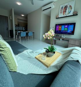sala de estar con sofá, mesa y TV en Greenfield Residence Sunway Subang 9Pax 3R2B with Internet, en Petaling Jaya