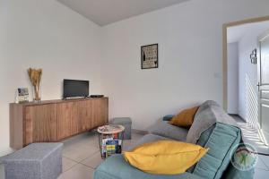 Les etangs في Liffré: غرفة معيشة مع أريكة وتلفزيون