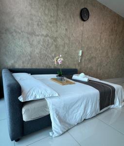 Una cama con una mesa y flores. en Greenfield Residence Sunway Subang 9Pax 3R2B with Internet, en Petaling Jaya