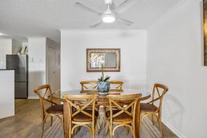 a dining room with a table with chairs and a ceiling fan at Stunning 3-Bed Retreat in Marcoola with Pool & Gym in Marcoola