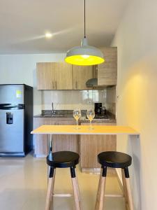 a kitchen with two wine glasses on a counter at LOFT SOHO ICÓNICO CON BALCÓN in Sabaneta