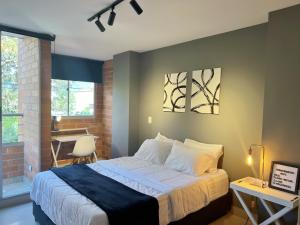 a bedroom with a bed and a table and a desk at LOFT SOHO ICÓNICO CON BALCÓN in Sabaneta +18 photos