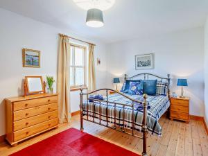 a bedroom with a bed and a dresser and a window at 3 Bed in Ardvasar CA071 in Aird of Sleat