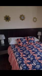 a bed in a bedroom with two mirrors on the wall at CASA LESLY in Cuenca