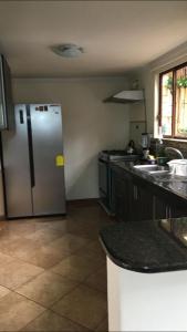 une cuisine avec un réfrigérateur et des comptoirs en acier inoxydable dans l'établissement CASA LESLY, à Cuenca