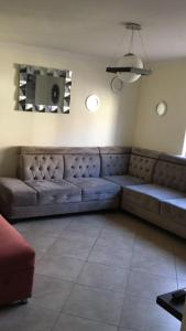 un soggiorno con un grande divano in una camera di CASA LESLY a Cuenca
