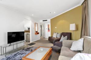 a living room with a couch and a tv at Quay West 2302 Self-Catering in Sydney