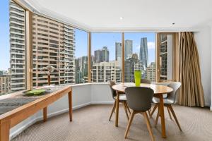 a dining room with a table and chairs and a large window at Quay West 2302 Self-Catering in Sydney