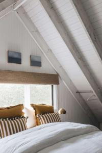 een slaapkamer met een bed met 2 kussens en een raam bij Coromandel Cottage, Berrima in Berrima