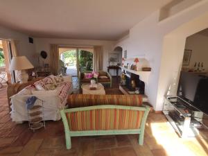 ein Wohnzimmer mit einem Sofa und einem TV in der Unterkunft Villa Grimaud, 6 pièces, 10 personnes - FR-1-780-10 in Grimaud