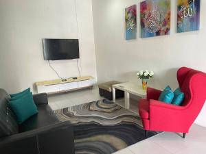 a living room with two chairs and a tv at Homestay Samsul Sungkai in Sungkai