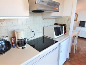 eine Küche mit einer Mikrowelle und einer Kaffeemaschine in der Unterkunft Appartement Sainte-Maxime, 1 pièce, 2 personnes - FR-1-780-37 in Sainte-Maxime