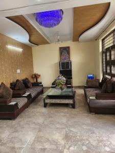a large living room with couches and a chandelier at Hotel New City Lite in New Delhi
